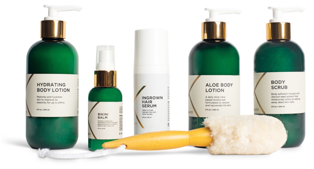 A collection of skincare products from Uni K Wax Studio, including Hydrating Body Lotion, Bikini Balm, Ingrown Hair Serum, Aloe Body Lotion, and Body Scrub, displayed with a body brush. The bottles are primarily green with white and gold labels.