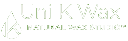 Logo for Uni K Wax Natural Wax Studio. The design includes a stylized droplet with the letter "K" inside it and the text "Uni K Wax" above "Natural Wax Studio™" in a clean, modern font. The colors are white on a dark background.
