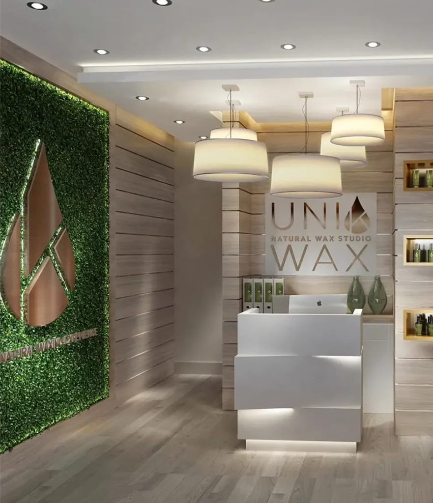 Modern wax studio reception with green wall decor.