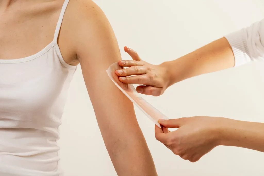 Applying a waxing strip to arm