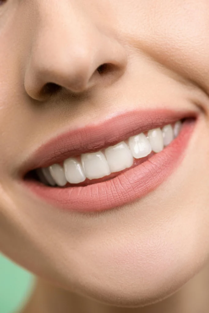 Close-up of a smiling mouth with pink lips.