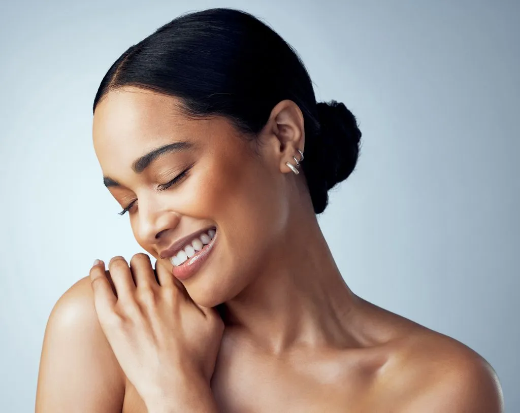 Smiling woman with closed eyes and bare shoulders.
