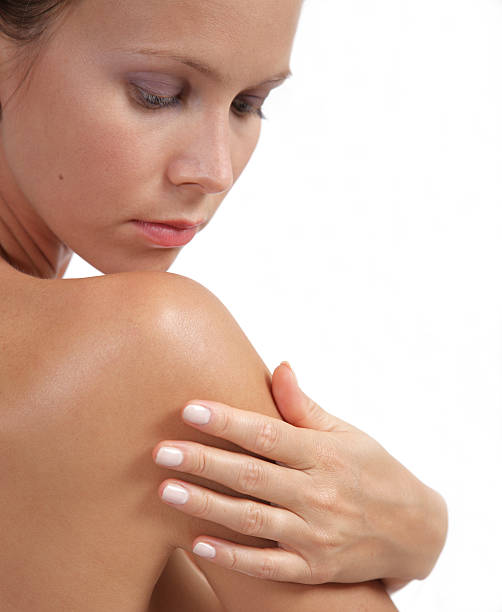 Woman touching her smooth shoulder, skincare concept.