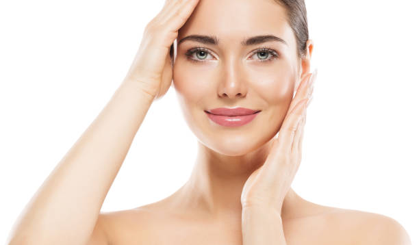Smiling woman with glowing skin touching face