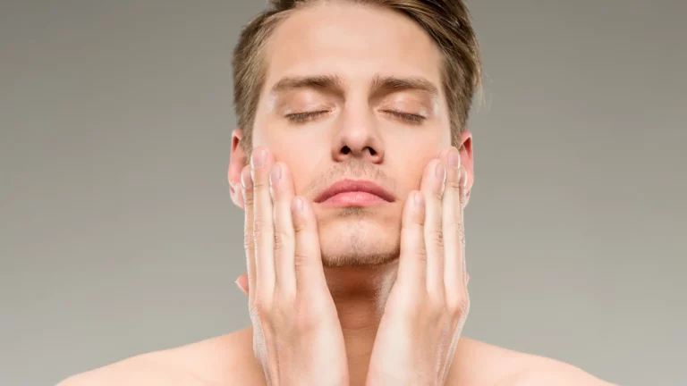 Man applying skincare with closed eyes