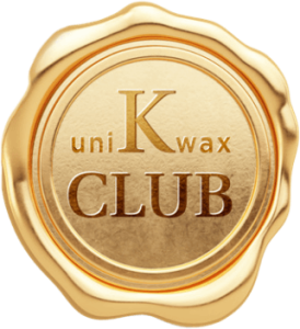 A gold wax seal with the text "uniKwax CLUB" embossed on it. The seal has a wavy, irregular edge, and a shiny, metallic appearance.
