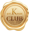 A gold wax seal with the text "uniKwax CLUB" embossed on it. The seal has a wavy, irregular edge, and a shiny, metallic appearance.